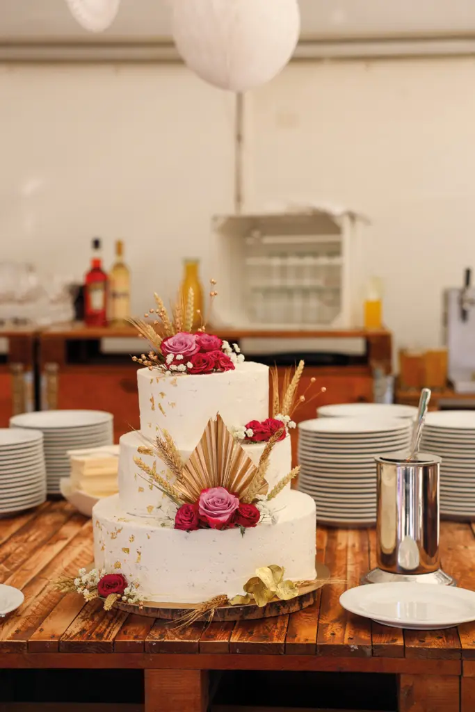 Dreistöckige Vintage-Creme-Torte in weiß mit Goldakzenten und roten Rosen