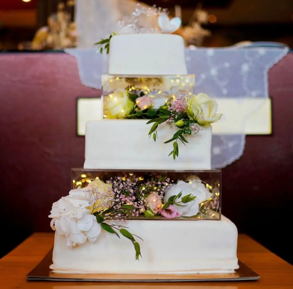 Individuelle Hochzeitstorte mit Blumen und Lichterketten