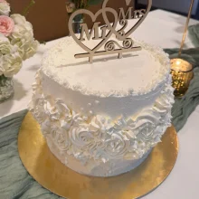 Weiße Vintage-Torte mit aufwändigem Stuck-Design und Mr. und Mrs. Aufsteller