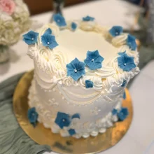 weiße Creme-Vintage-Torte mit blauen Blumen