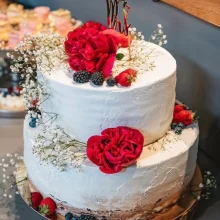 Zweistöckige Creme-Hochzeitstorte mit Schleierkraut und Rosen