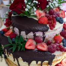 Naked-Cake mit Schokoladen-Drip, Erdbeeren, Himbeeren, Rosen und Schleierkraut
